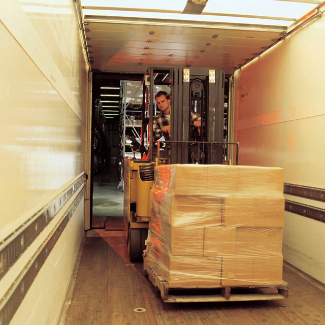 Cargo being loaded with a forklift inside of a semi truck trailer
