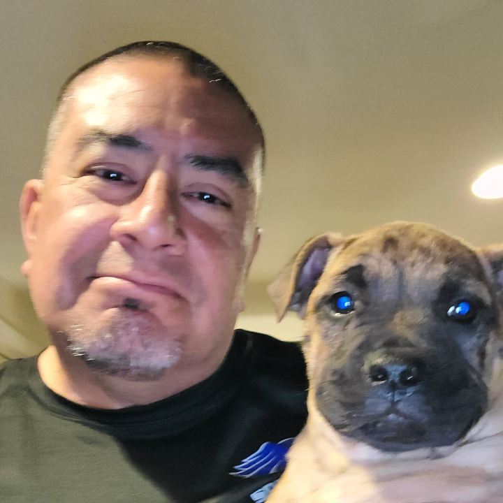 Headshot of Service Driven Transportation Employee Manny standing next to his dog